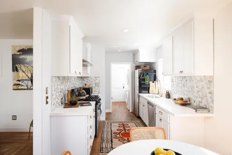 a kitchen with stainless steel appliances a refrigerator a sink a stove a microwave and cabinets