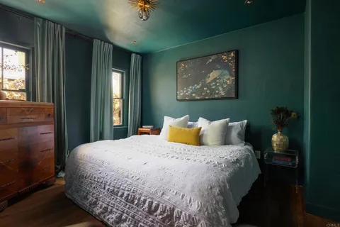 a bed sitting in a bedroom next to a window