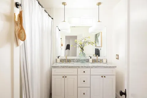 a bathroom with a granite countertop sink and a mirror