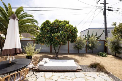 a view of a backyard with couches under an umbrella