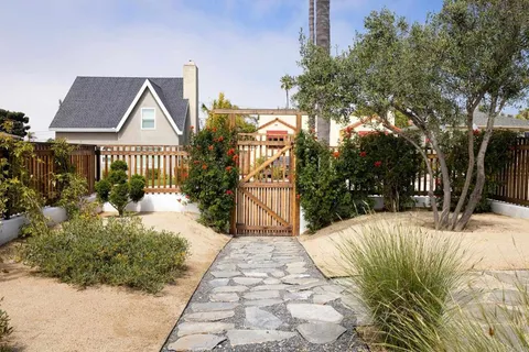 a vase of flowers sitting on a table with potted plants