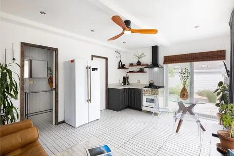 a kitchen with stainless steel appliances a stove a refrigerator sink and wooden floor