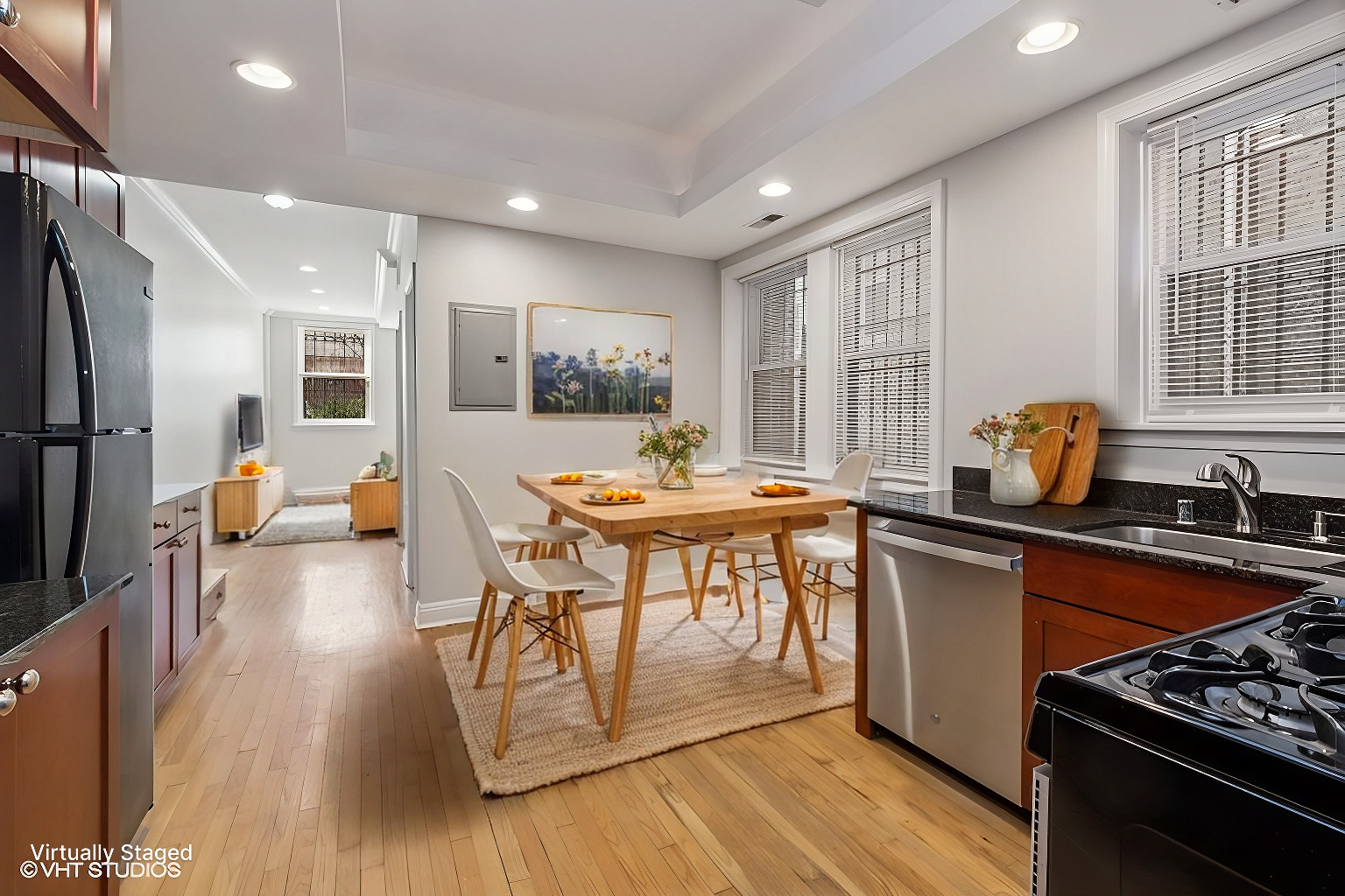 4909 North Janssen Avenue, Unit GDN Chicago, IL 60640 - Photo 5 of 8 a kitchen with stainless steel appliances granite countertop a stove top oven a sink dishwasher a dining table and chairs with wooden floor