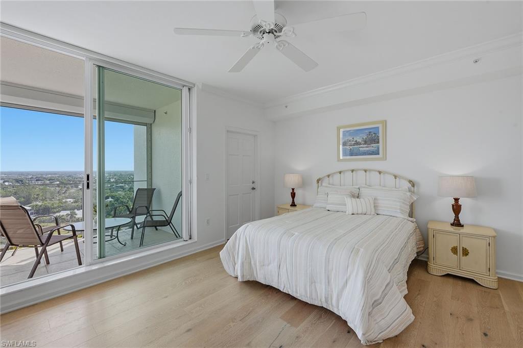 60 Seagate Drive, Unit 1606 Naples, FL 34103 - Photo 15 of 44 a bedroom with a bed and a chandelier