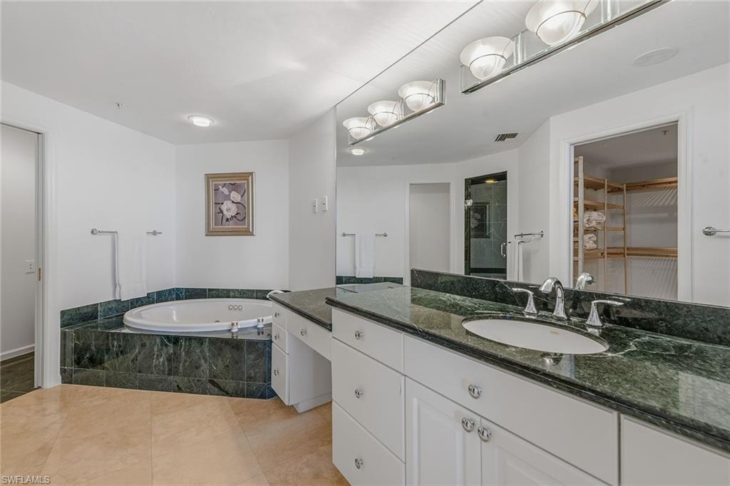 60 Seagate Drive, Unit 1606 Naples, FL 34103 - Photo 23 of 44 a bathroom with a granite countertop sink and a mirror
