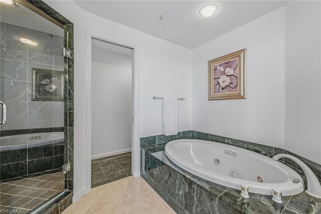 60 Seagate Drive, Unit 1606 Naples, FL 34103 - Photo 24 of 44 a bathroom with a tub and a shower