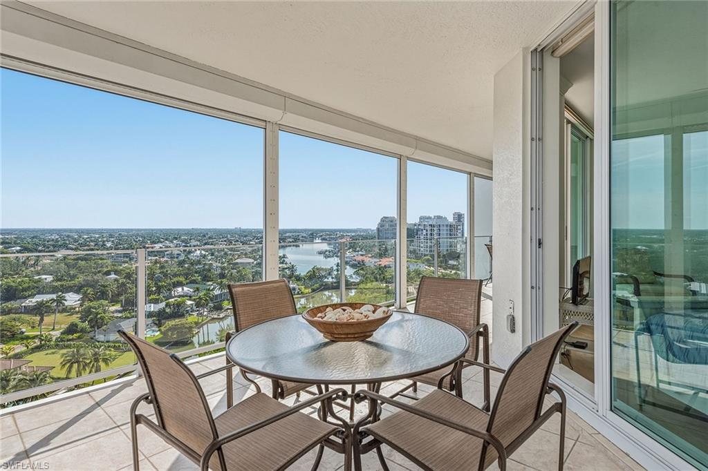60 Seagate Drive, Unit 1606 Naples, FL 34103 - Photo 25 of 44 a view of a patio with a table and chairs