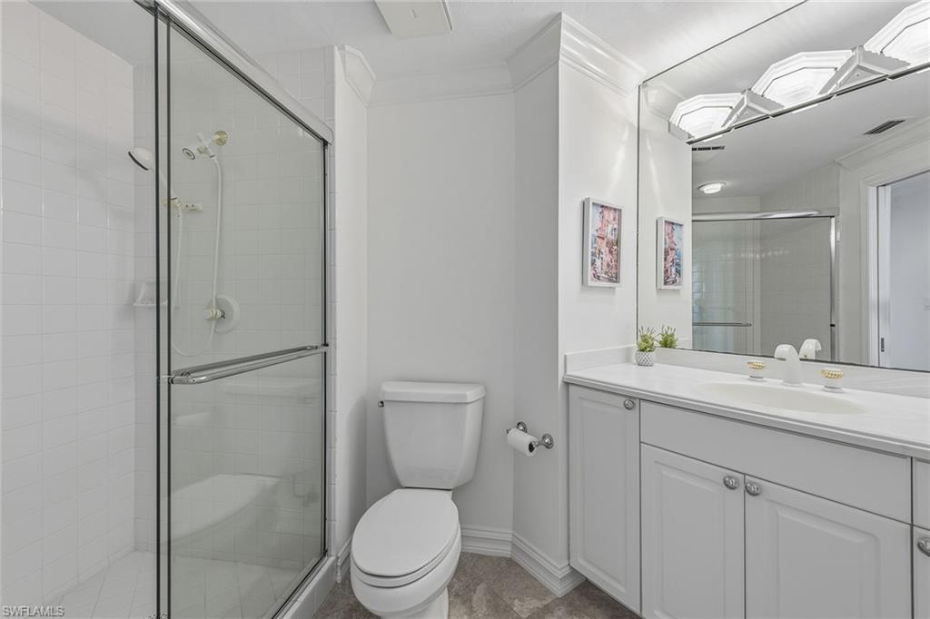 60 Seagate Drive, Unit 1606 Naples, FL 34103 - Photo 26 of 44 a bathroom with a toilet sink vanity and mirror
