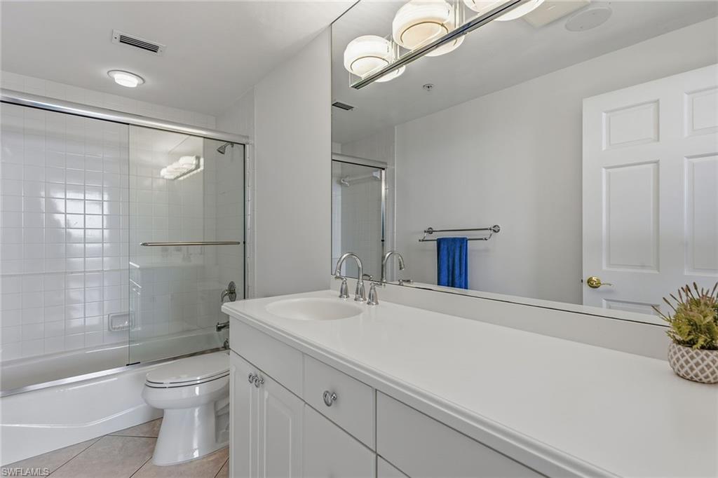 60 Seagate Drive, Unit 1606 Naples, FL 34103 - Photo 28 of 44 a bathroom with a sink a toilet and shower