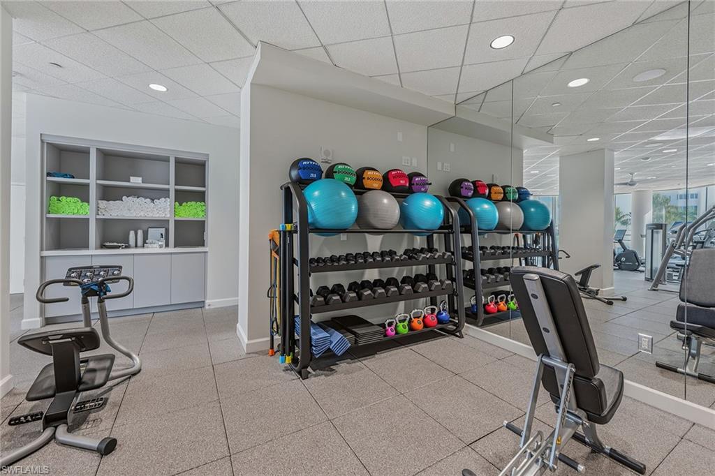60 Seagate Drive, Unit 1606 Naples, FL 34103 - Photo 40 of 44 a bedroom with furniture a chandelier and a window