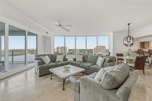 a living room with furniture and a floor to ceiling window