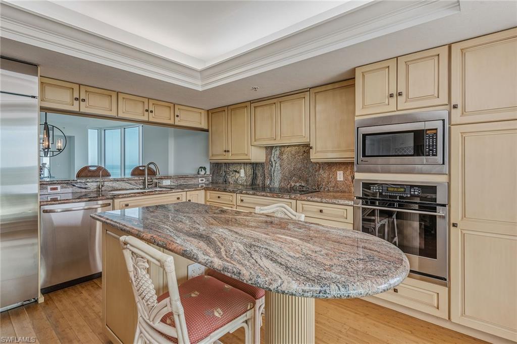 60 Seagate Drive, Unit 1606 Naples, FL 34103 - Photo 8 of 44 a kitchen with stainless steel appliances granite countertop a sink stove microwave and refrigerator