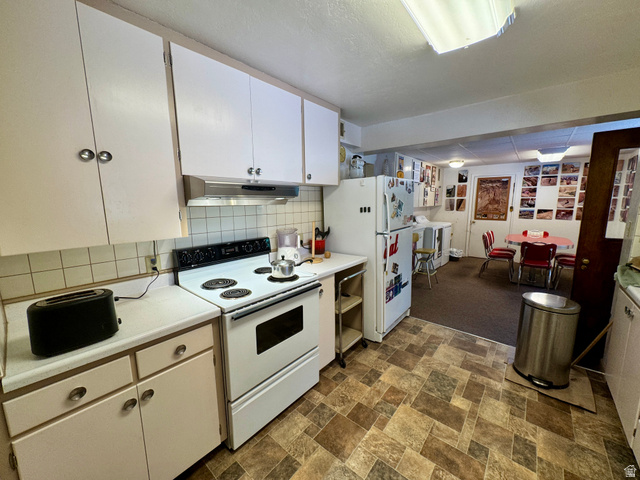 178 Walnut Lane Moab, UT 84532 - Photo 12 of 25 Functional kitchen featuring white cabinetry, a white electric range, and a rectangular tile backsplash