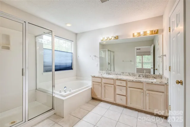 a bathroom with a tub sink and mirror