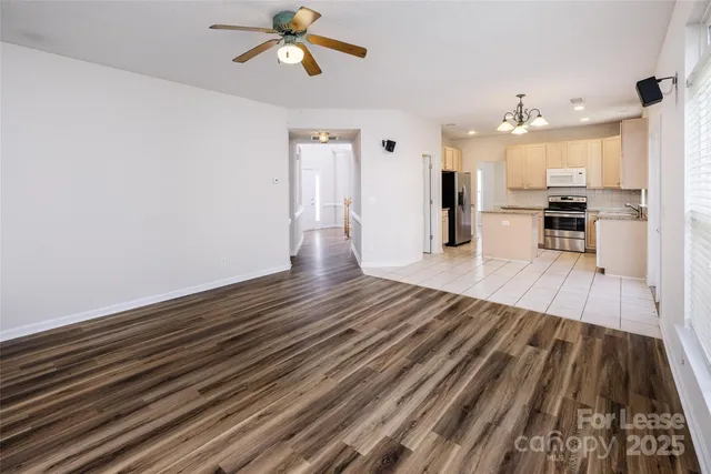 a view of a living room with wooden floor and ceiling fan