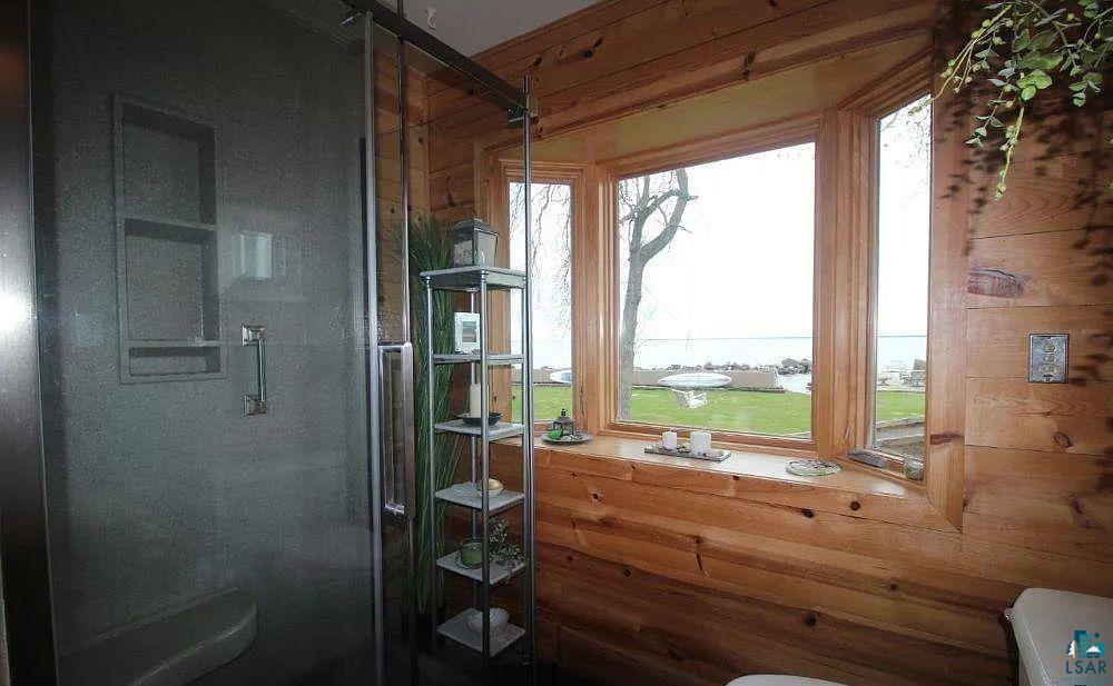 6431 Summit Avenue Washburn, WI 54891 - Photo 20 of 25 Bathroom with a shower stall, a water view, and wooden walls