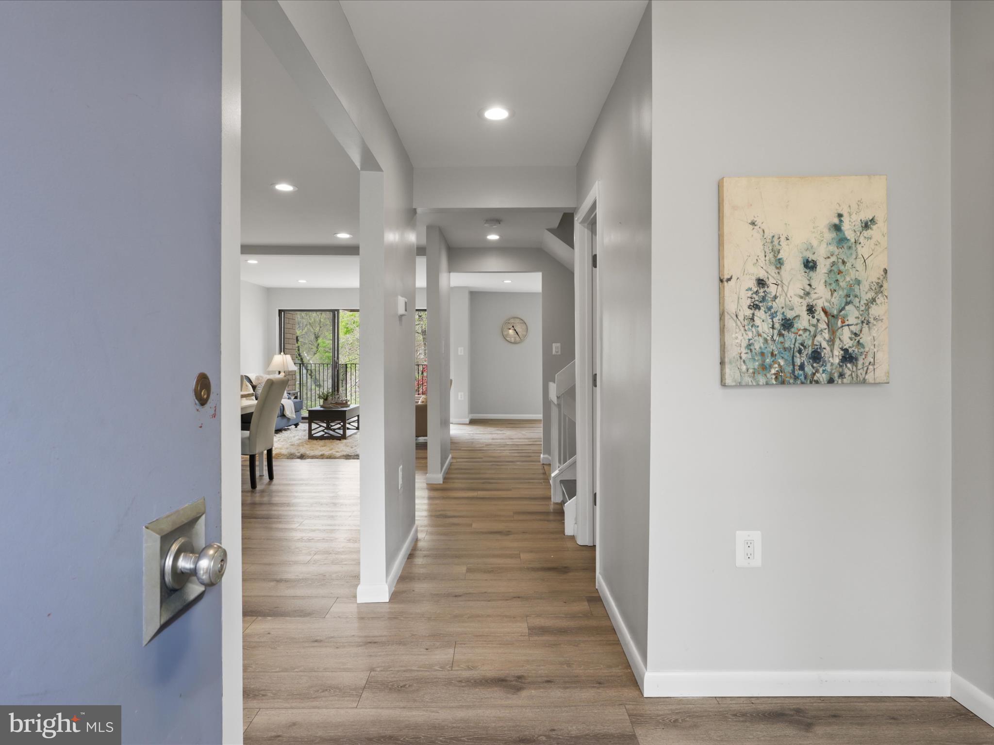 11159 Saffold Way Reston, VA 20190 - Photo 14 of 51 a view of a hallway with wooden floor windows and a livingroom
