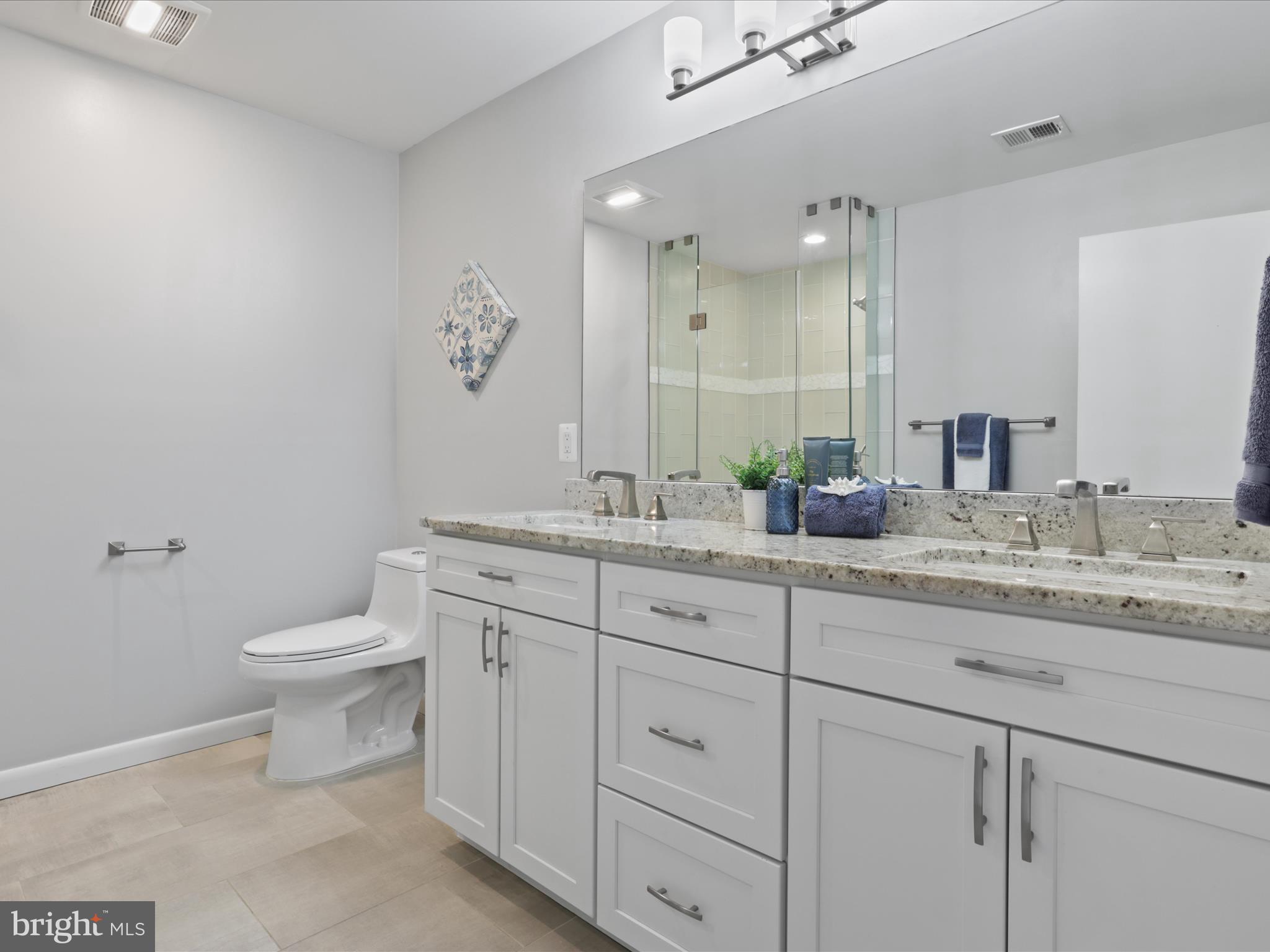 11159 Saffold Way Reston, VA 20190 - Photo 25 of 51 a bathroom with a granite countertop sink a toilet and a mirror