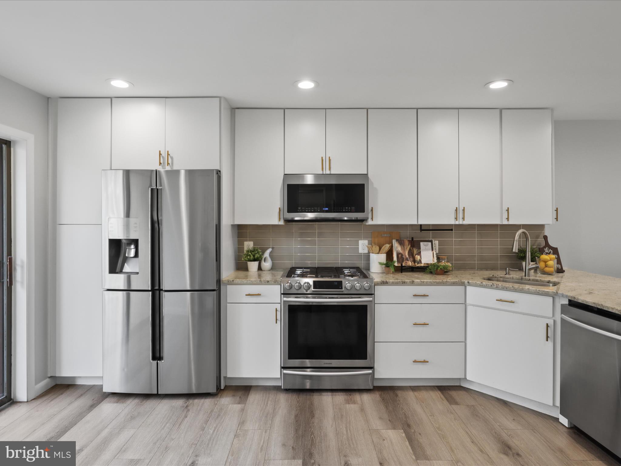 11159 Saffold Way Reston, VA 20190 - Photo 4 of 51 a kitchen with stainless steel appliances granite countertop a stove a refrigerator and a microwave