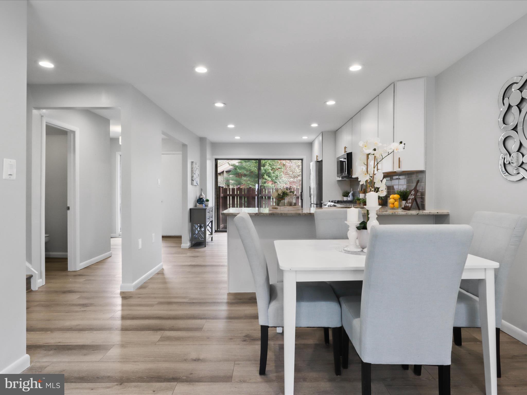 11159 Saffold Way Reston, VA 20190 - Photo 9 of 51 a dining hall with stainless steel appliances kitchen island granite countertop a table chairs and a refrigerator