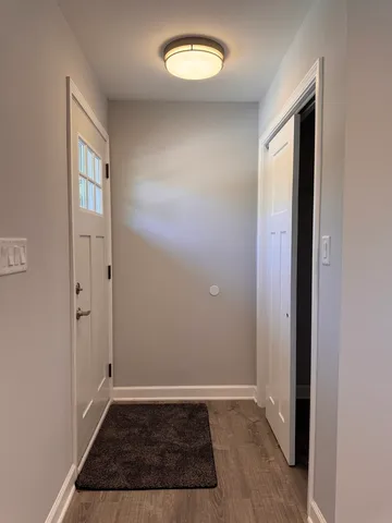 an empty room with wooden floor and a window