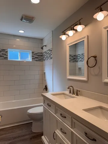 a bathroom with a sink a toilet and shower