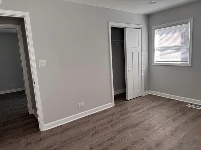 an empty room with wooden floor and closet