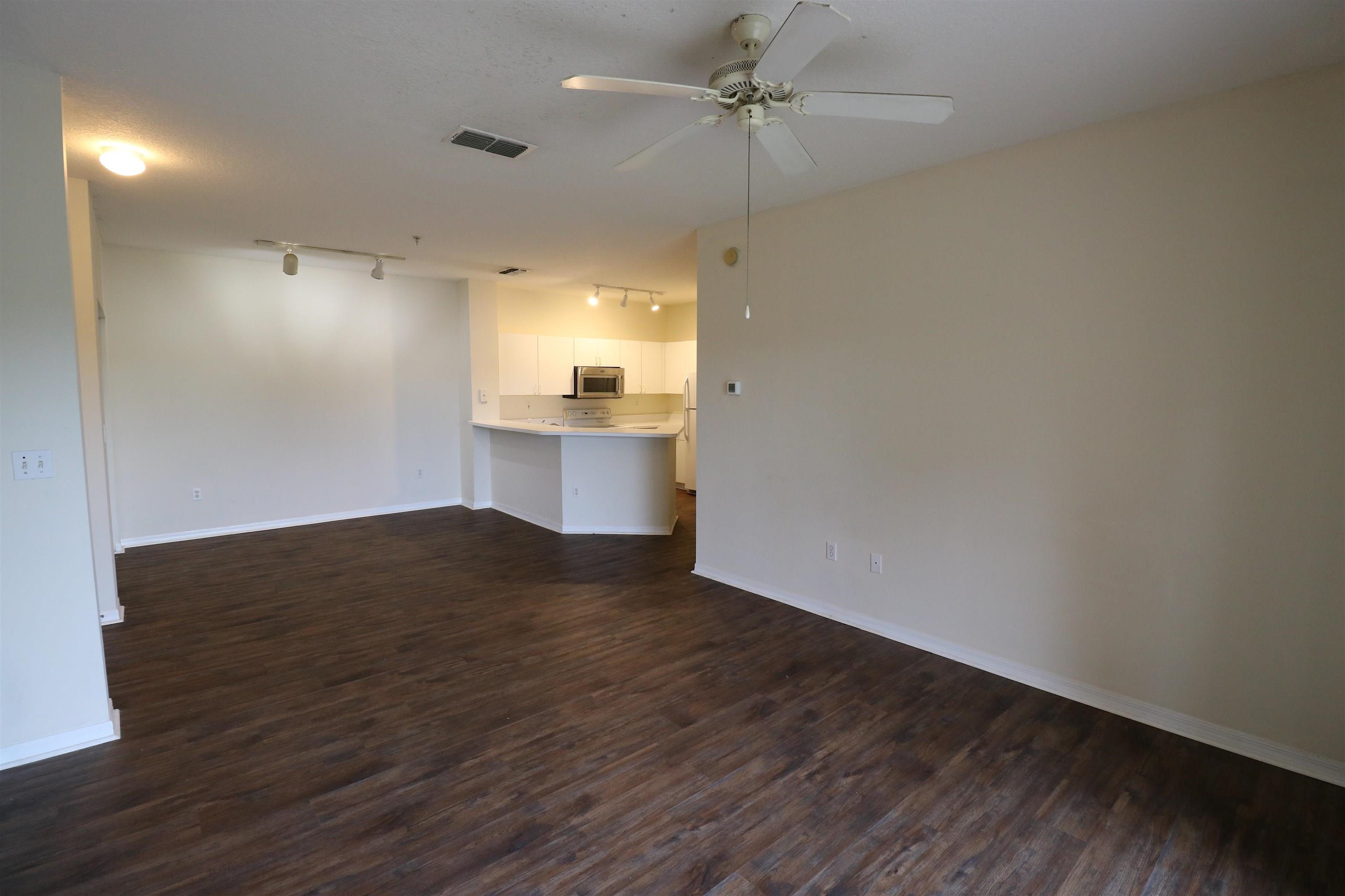625 Fairway Drive, Unit 302 St. Augustine, FL 32084 - Photo 4 of 22 a view of empty room with wooden floor and fan