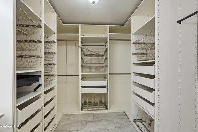 a view of walk in closet with empty racks