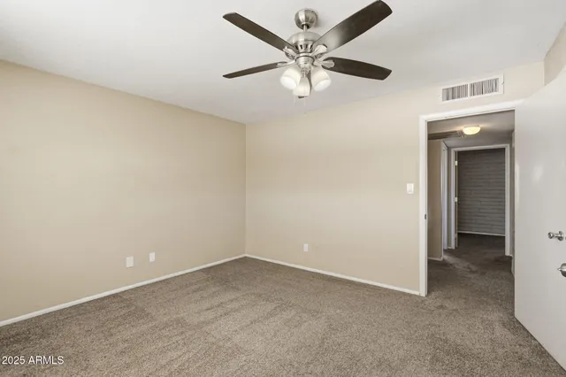 an empty room with a ceiling fan and a fan