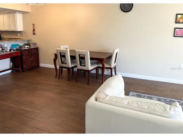 a living room with furniture and a dining table with kitchen view