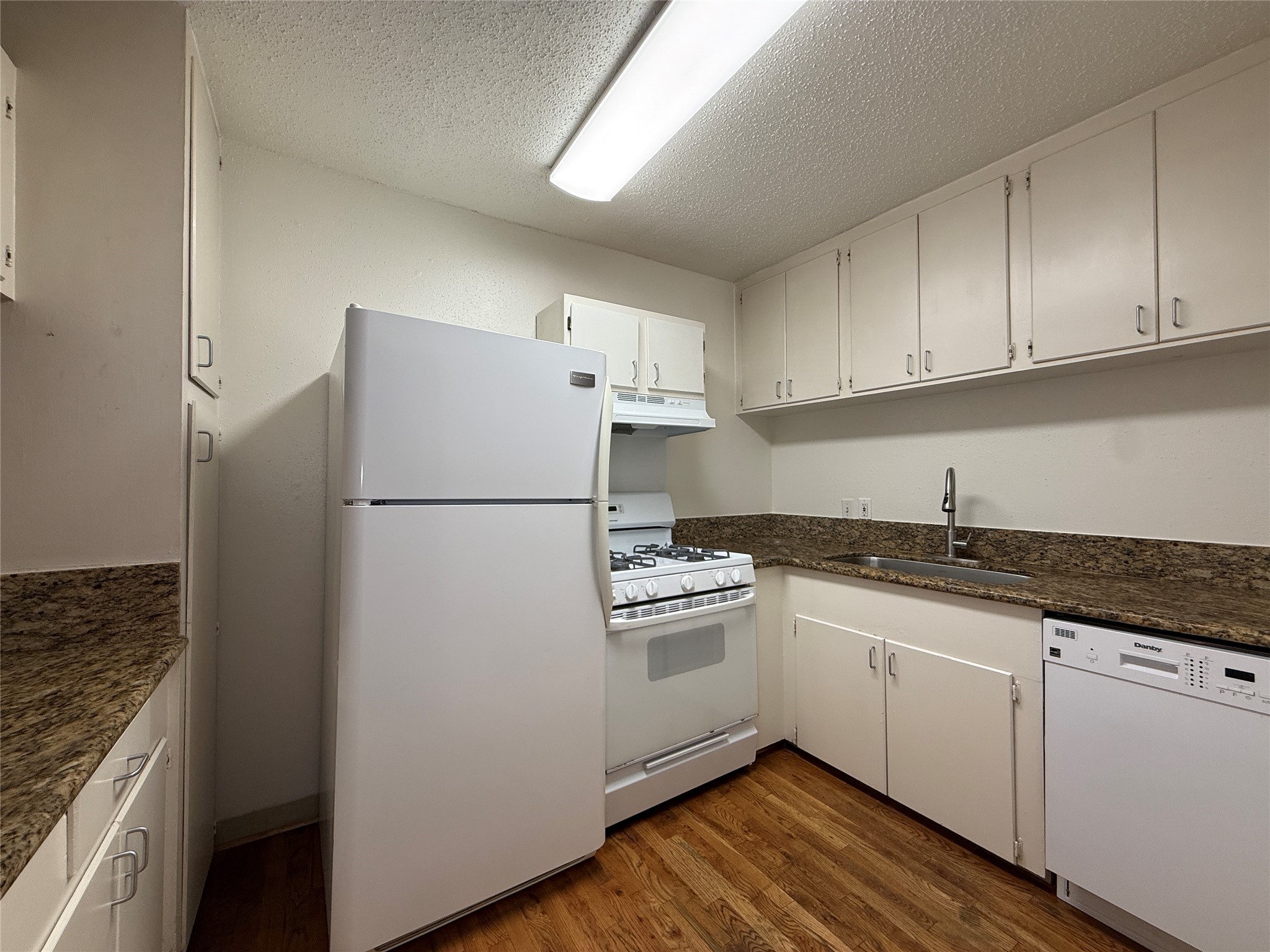1801 Cortlandt Street, Unit 16 Houston, TX 77008 - Photo 13 of 35 a kitchen with granite countertop white cabinets and white appliances