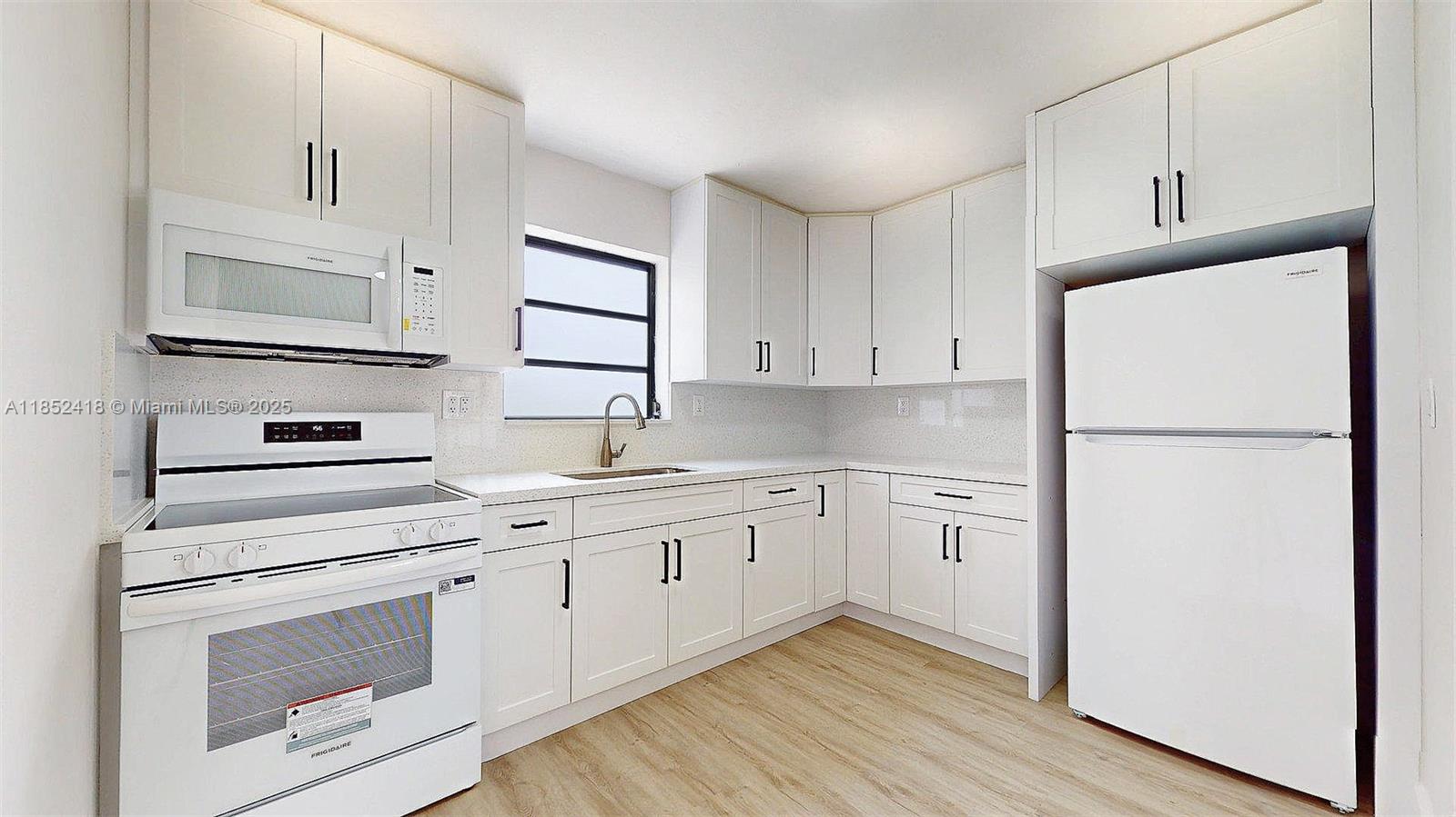 1674 West 42nd Street, Unit 1674 Hialeah, FL 33012 - Photo 11 of 29 a kitchen with cabinets stainless steel appliances and wooden floor