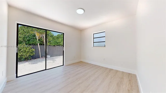 a bedroom with a balcony a bed and a painting on the wall