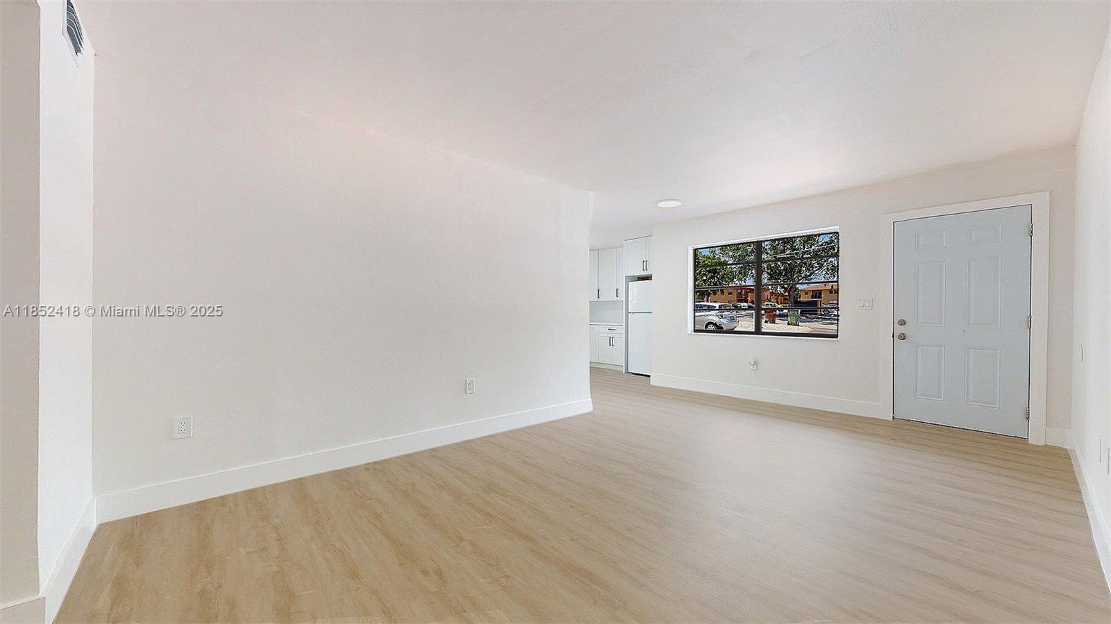 1674 West 42nd Street, Unit 1674 Hialeah, FL 33012 - Photo 5 of 29 an empty room with wooden floor and windows