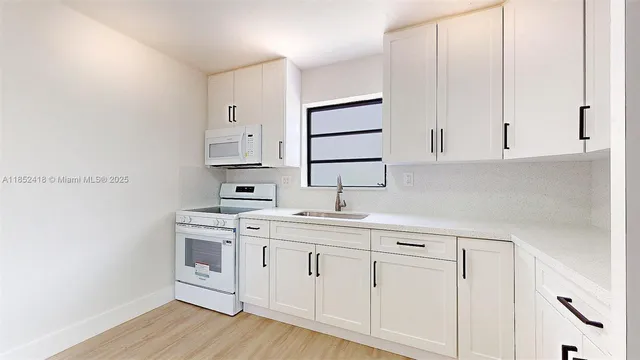 a kitchen with cabinets stainless steel appliances and wooden floor