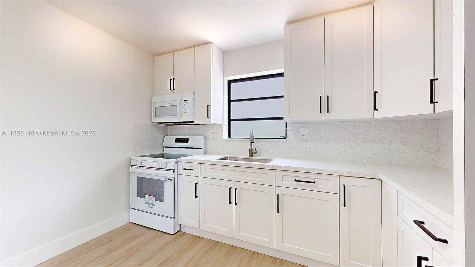 1674 West 42nd Street, Unit 1674 Hialeah, FL 33012 - Photo 10 of 29 a kitchen with white cabinets and sink