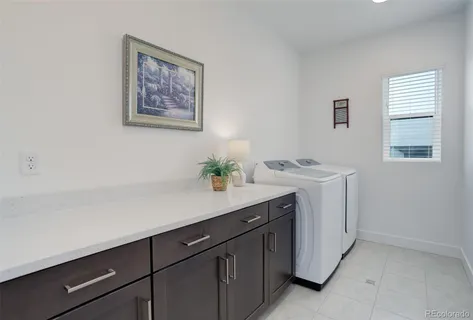 a room with a sink cabinets and washer