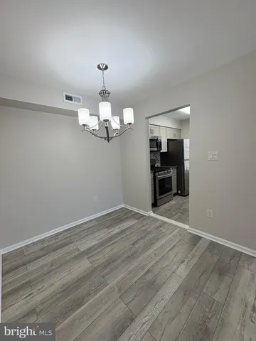 wooden floor in an empty room with a chandelier