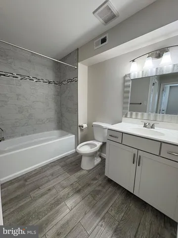 a bathroom with a double vanity sink toilet mirror and bathtub