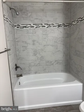 a bathroom with a shower and a bath tub
