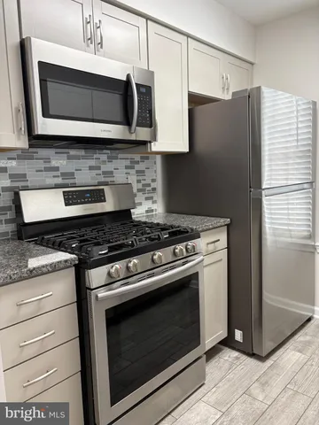 a stove top oven sitting inside of a kitchen