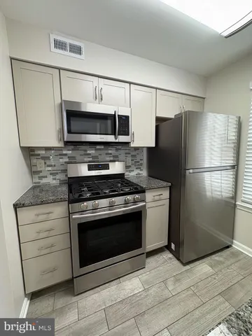 a kitchen with stainless steel appliances a refrigerator stove and microwave
