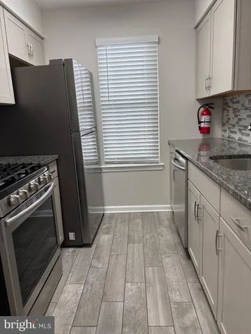 a kitchen with granite countertop a stove and a refrigerator