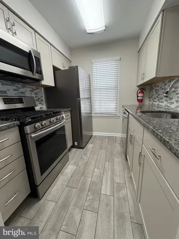 a kitchen with granite countertop a stove and a sink