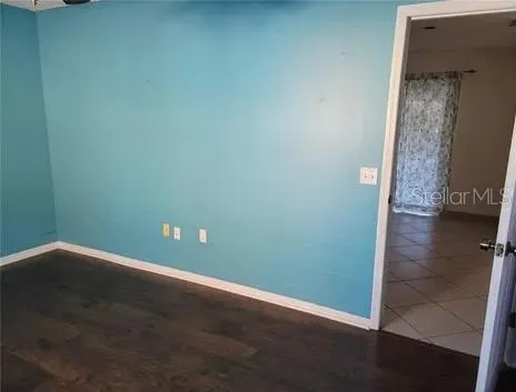 an empty room with wooden floor and entrance