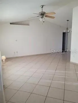 an empty room with a ceiling fan and carpet