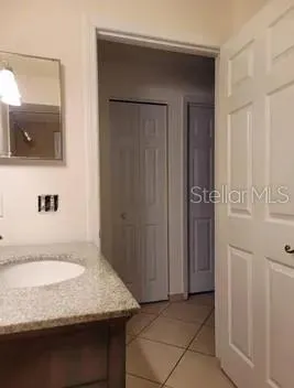 a bathroom with a granite countertop sink and a mirror