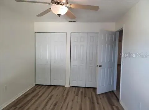 a view of an empty room with wooden floor