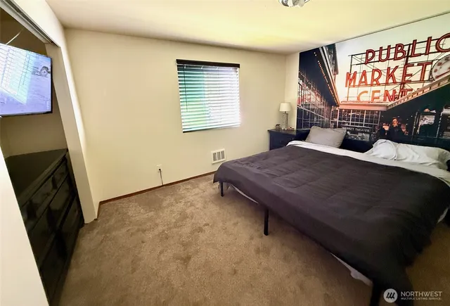 a bed sitting in a bedroom next to a window